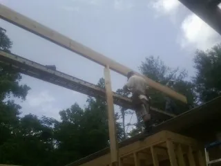 Carpenter setting a ridge beam over a new addition frame — Ice Dam Removal by Roofing Brothers in Drakesville